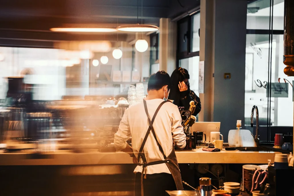 日本のカフェでアルバイトをしている外国人留学生の後ろ姿