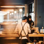 日本のカフェでアルバイトをしている外国人留学生の後ろ姿