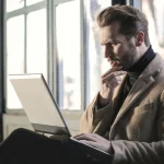 「うまい話」を聞きPCで調べている男性