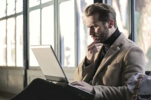 「うまい話」を聞きPCで調べている男性