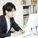 パソコンでビジネスメールを作成している男性