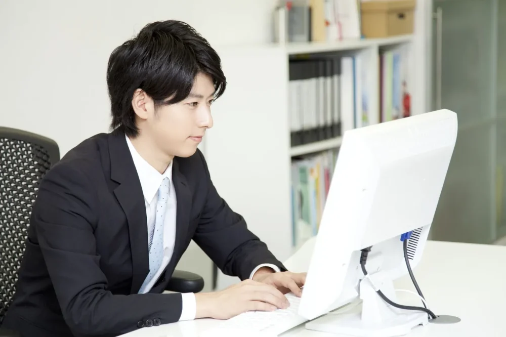 パソコンでビジネスメールを作成している男性